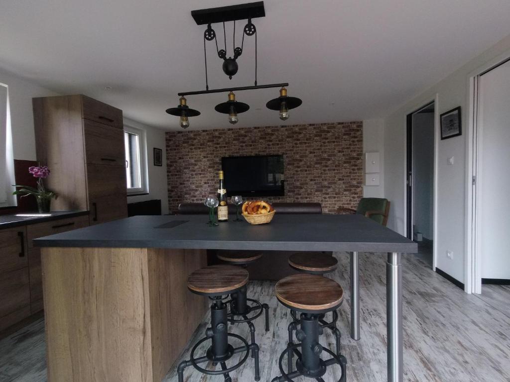 a kitchen with a large island with bar stools at Gîte d’Alsace l’Escale in Ostheim