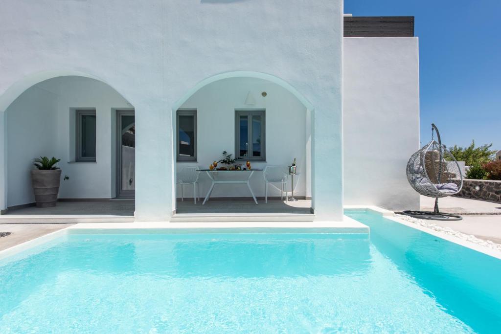 a villa with a swimming pool and a bathroom at White Harmony Suites in Megalokhori