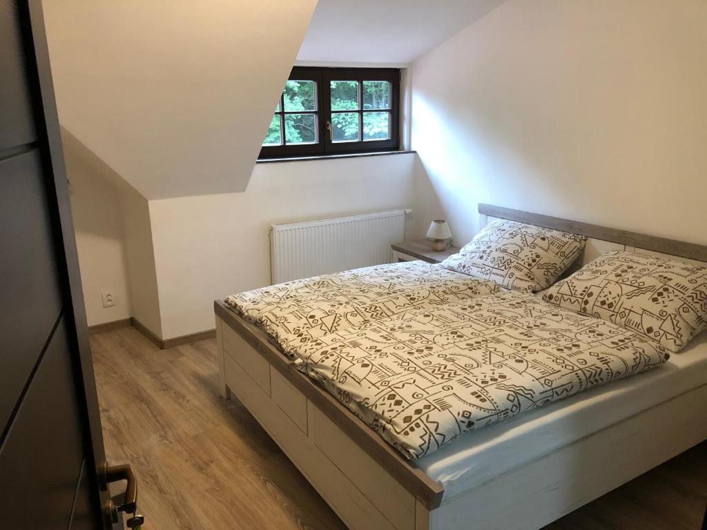 a bedroom with a bed and a window at Penzion U Adama in Karlštejn