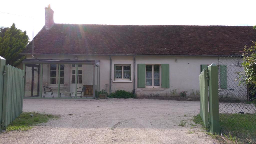 a small white house with a gate in front of it at maison de campagne in Cour-Cheverny