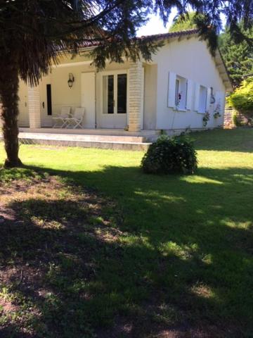 Biały dom z drzewem w ogrodzie w obiekcie Les Pierrottes pour 2 w mieście Mornac