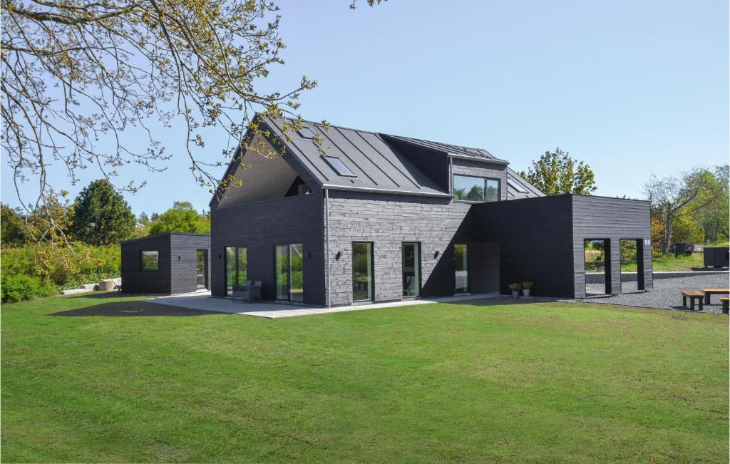 una casa con tetto nero e un cortile verde di Gorgeous Home In Ebeltoft With Kitchen a Ebeltoft