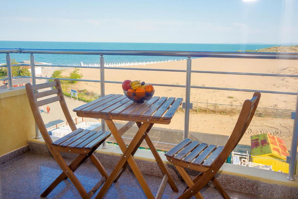 een tafel met fruit op een balkon met uitzicht op het strand bij Apartments Kristal Beach Nessebar in Nesebar