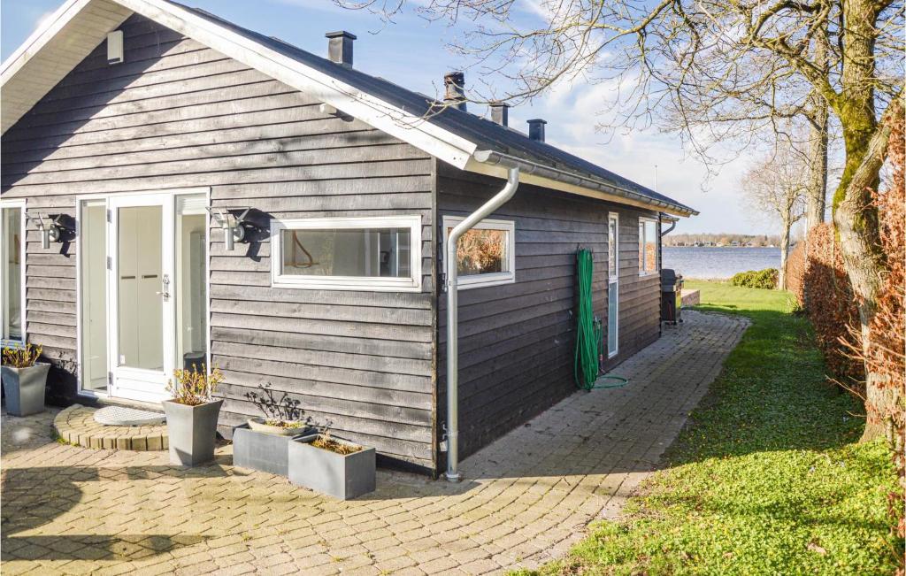 a small house with a green door and a window at Awesome Home In Sunds With House Sea View in Sunds