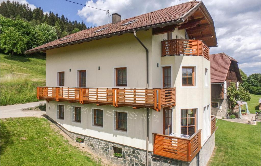 una casa con balcones de madera en un lateral en Gorgeous Apartment In Techelsberg With House A Mountain View en Sankt Martin am Techelsberg