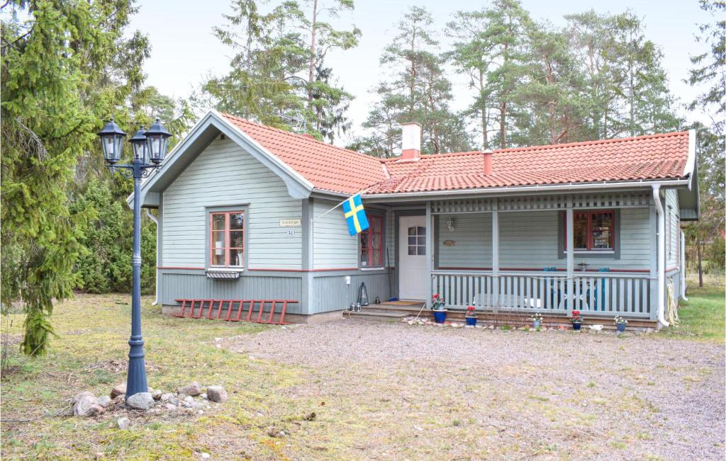 Una pequeña casa azul con una bandera. en 3 Bedroom Awesome Home In Mnsters, en Mönsterås