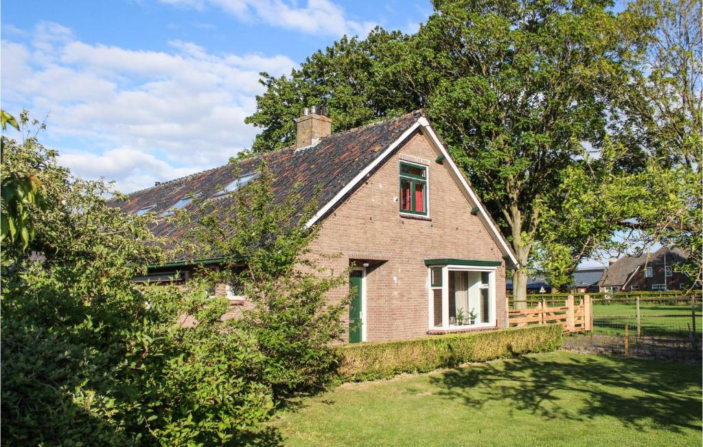 una piccola casa di mattoni in un cortile con recinto di Boerenzwaluw a Kamperveen