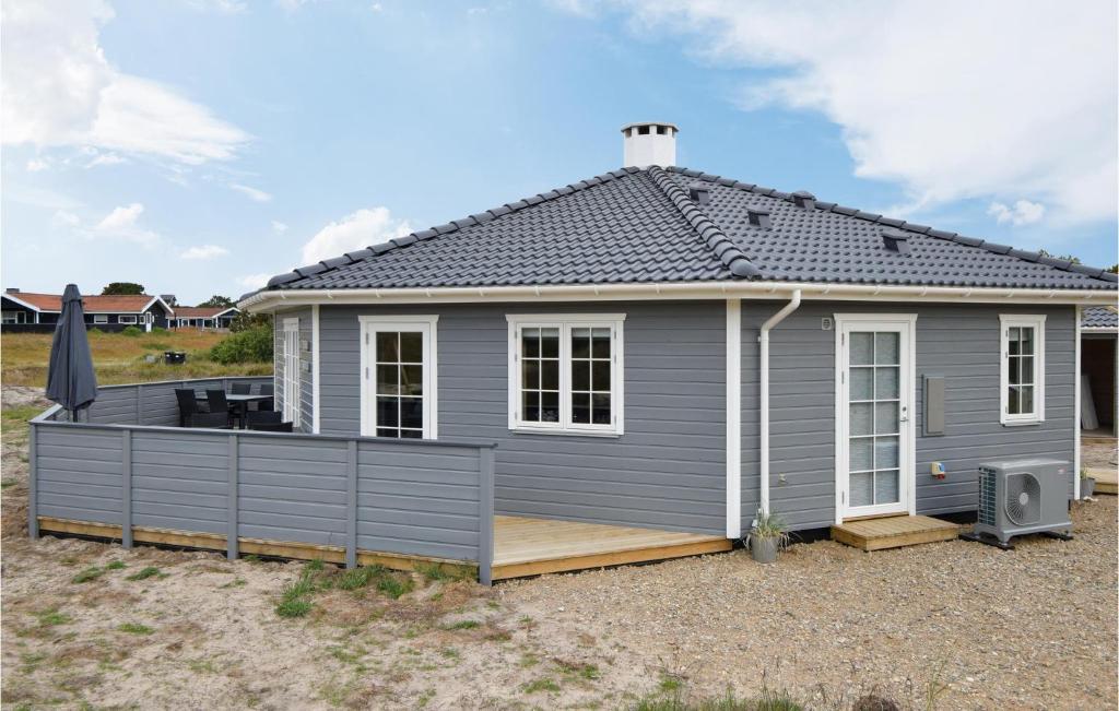 ein graues Haus mit einer Terrasse im Hof in der Unterkunft Cozy Home In Fan With Kitchen in Fanø
