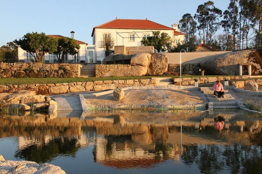 uma pessoa sentada ao lado de um lago de água em Quinta Vale Porcacho na Tábua