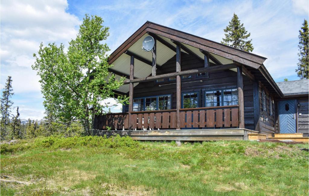 a large wooden house on a grassy hill at 3 Bedroom Amazing Home In Nord-torpa in Nord Torpa