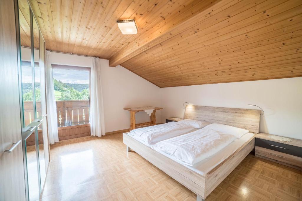 a bedroom with a bed and a wooden ceiling at Greif - Apartment C in Verano