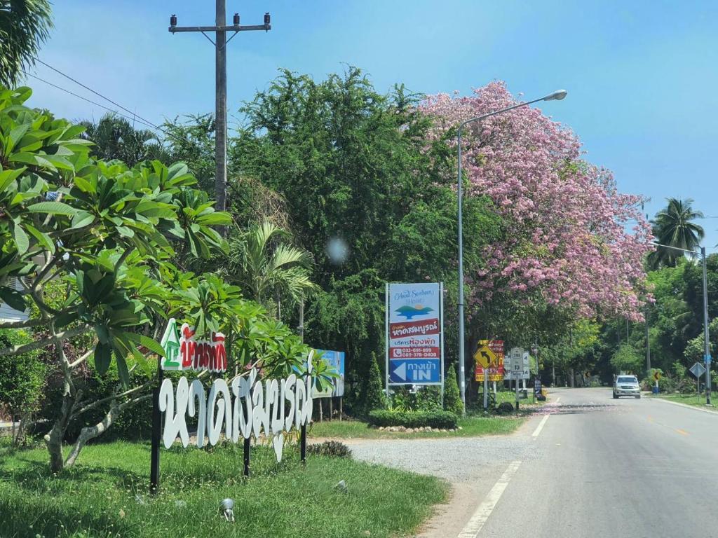 una calle con señales a un lado de la carretera en Haad Somboon House, en Bang Saphan