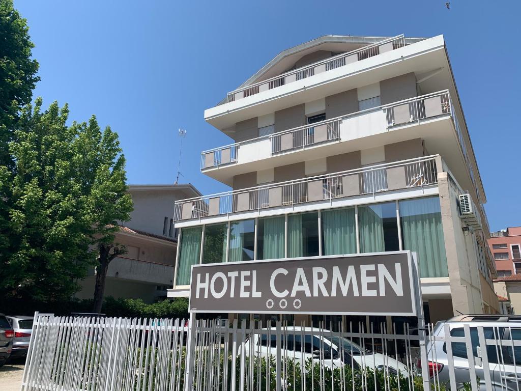 un panneau d'hôtel devant un bâtiment dans l'établissement Hotel Carmen, à Riccione