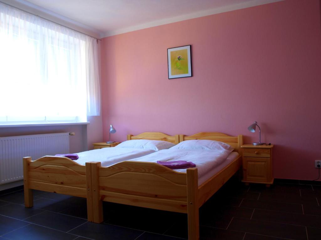 Drnholec的住宿－Penzion U Dvou lip，一间卧室配有一张床和粉红色的墙壁