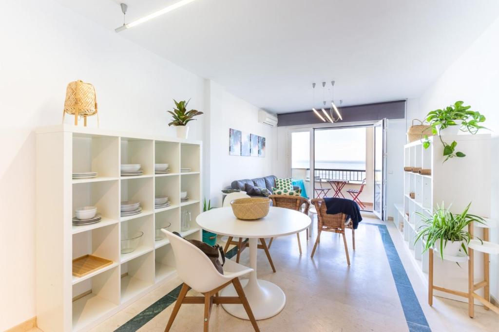 - une salle à manger et un salon avec une table et des chaises dans l'établissement Bonito Apartamento en Primera Línea de Playa, à Estepona
