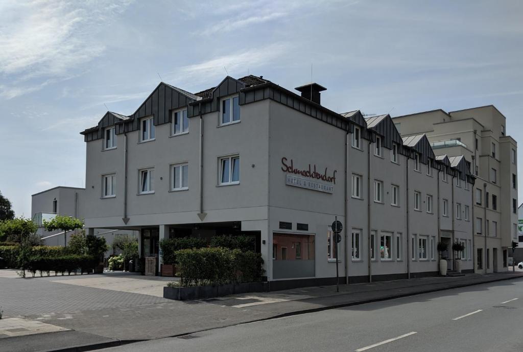 a large white building on the side of a street at Hotel Schmachtendorf in Oberhausen