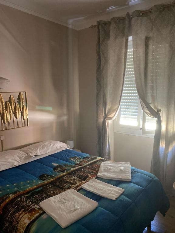 un letto con due asciugamani sopra con una finestra di Hotel Primavera a Sanremo