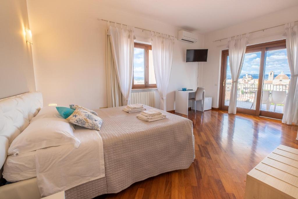 a bedroom with a bed and a couch and windows at Marysel Rooms in Olbia