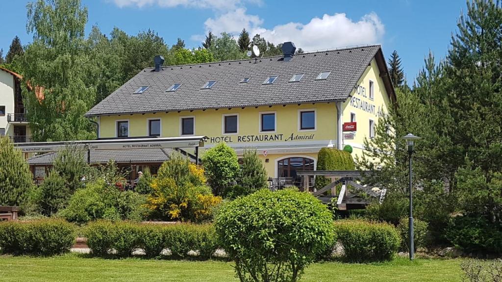 a large yellow building with a sign on it at Hotel Admiral in Lipno nad Vltavou