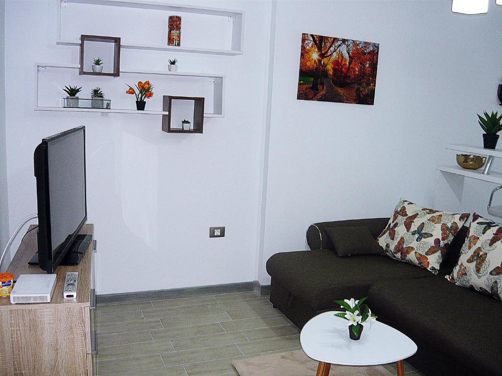 ein Wohnzimmer mit einem Sofa und einem TV in der Unterkunft Apartament Sunny Holiday in Mamaia Nord – Năvodari
