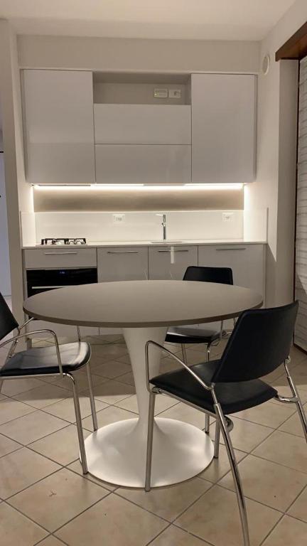a kitchen with a white table and two chairs at Monolocale Campo Romano in Schio