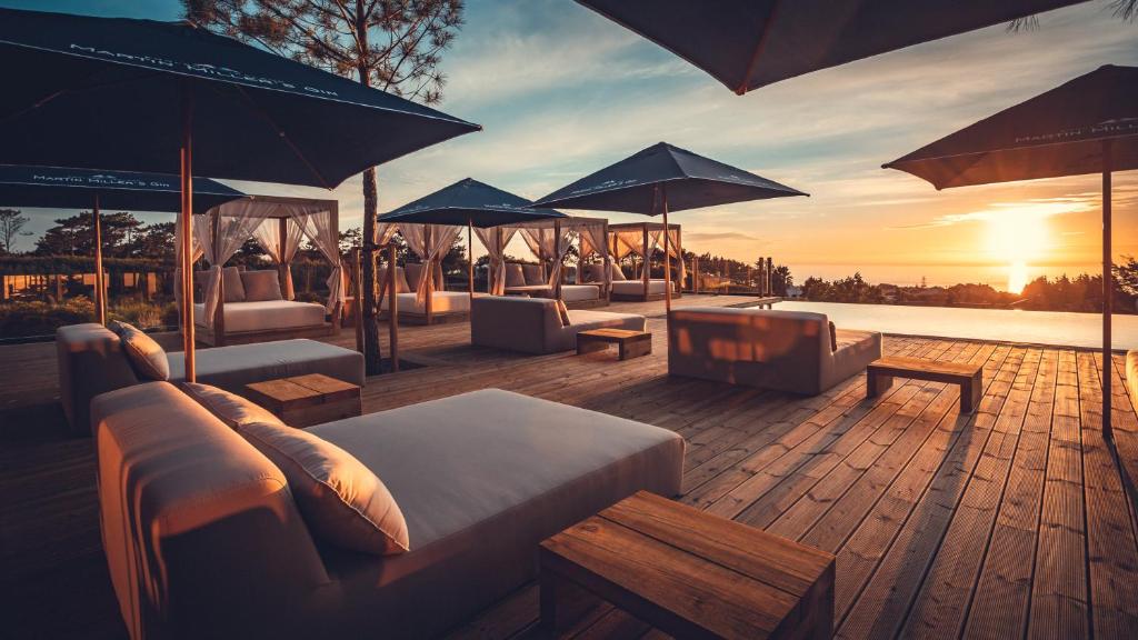 a deck with couches and umbrellas on a roof at Charm Nature in Azoia