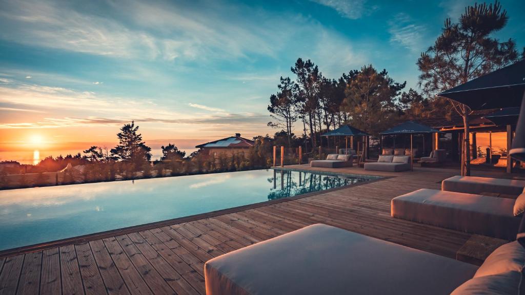 a swimming pool with a sunset in the background at Charm Nature in Azoia