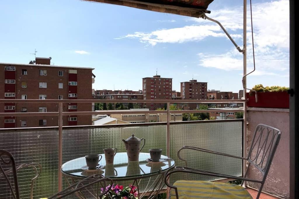 einen Tisch und Stühle auf einem Balkon mit Stadtblick in der Unterkunft 2 baños! Piso grande 100 m2 y Garaje gratis in Madrid