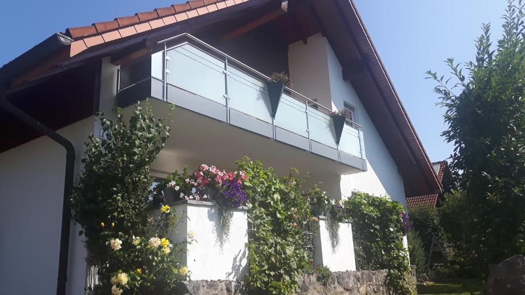un edificio con un balcón con flores. en Ferienwohnung Schwarzwaldglück, en Löffingen