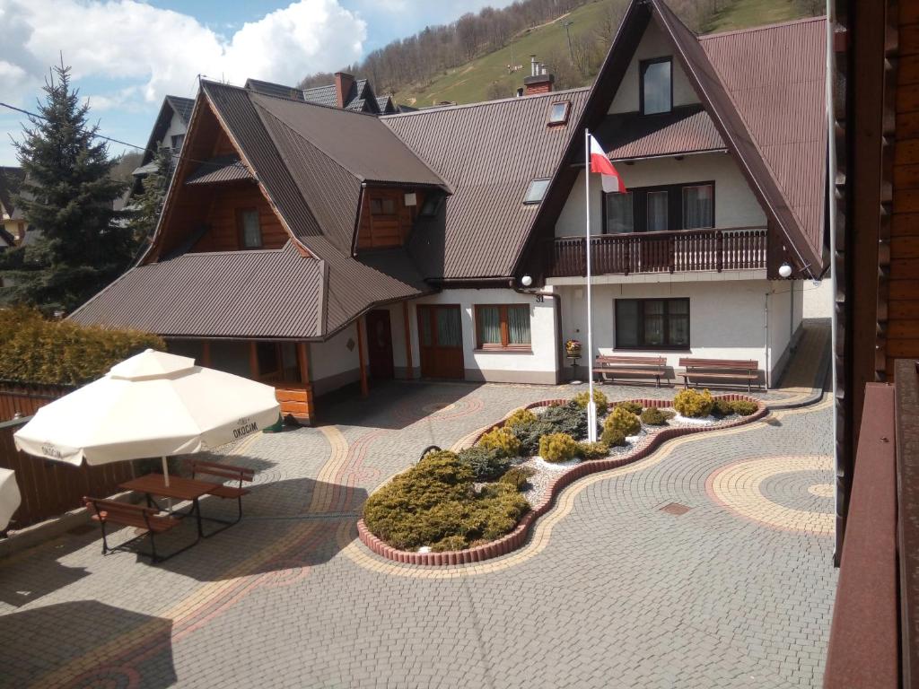 a house with a patio with an umbrella and a bench at U KOMINKA in Zakopane