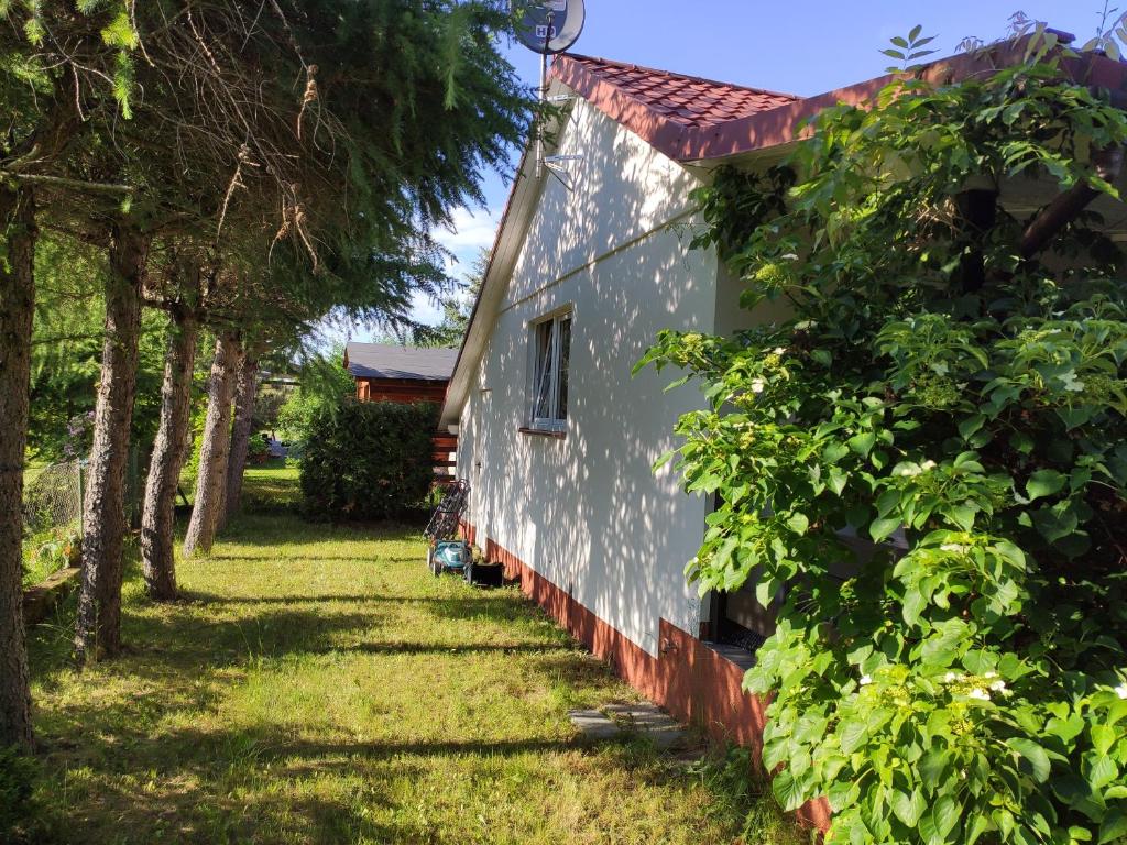 un lado de una casa con árboles al lado en Dom Nad Jeziorem, en Szteklin
