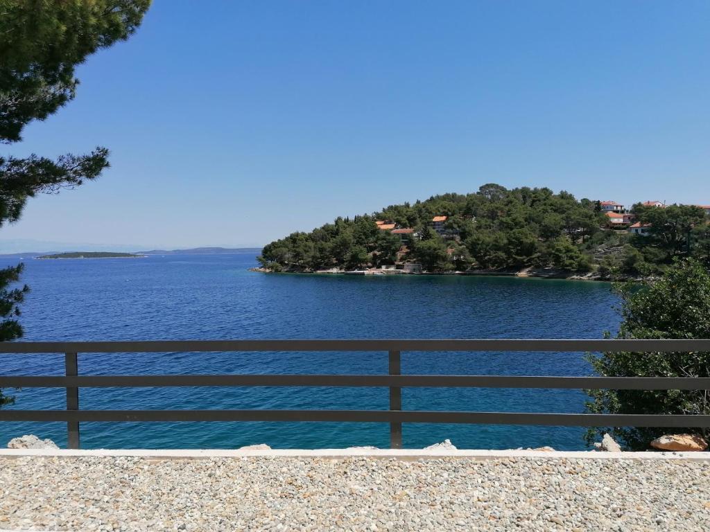 una vista de un gran cuerpo de agua con una valla en Apartman Bella 2, en Sali