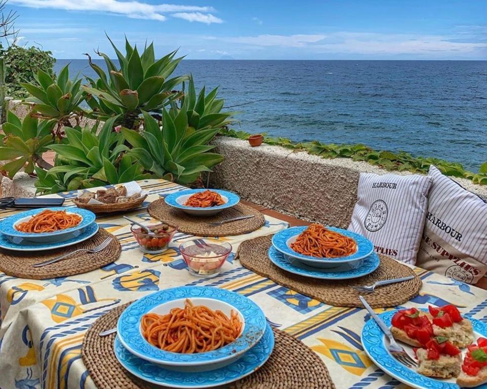 a table with plates of food on top of the ocean at Casa delle Galee in Scilla