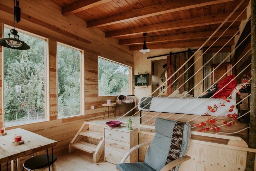 Habitación con escritorio y sillas en una cabaña de madera. en Bonita cabaña de los arboles en La Rioja , Durmiendo entre arboles, en Anguciana