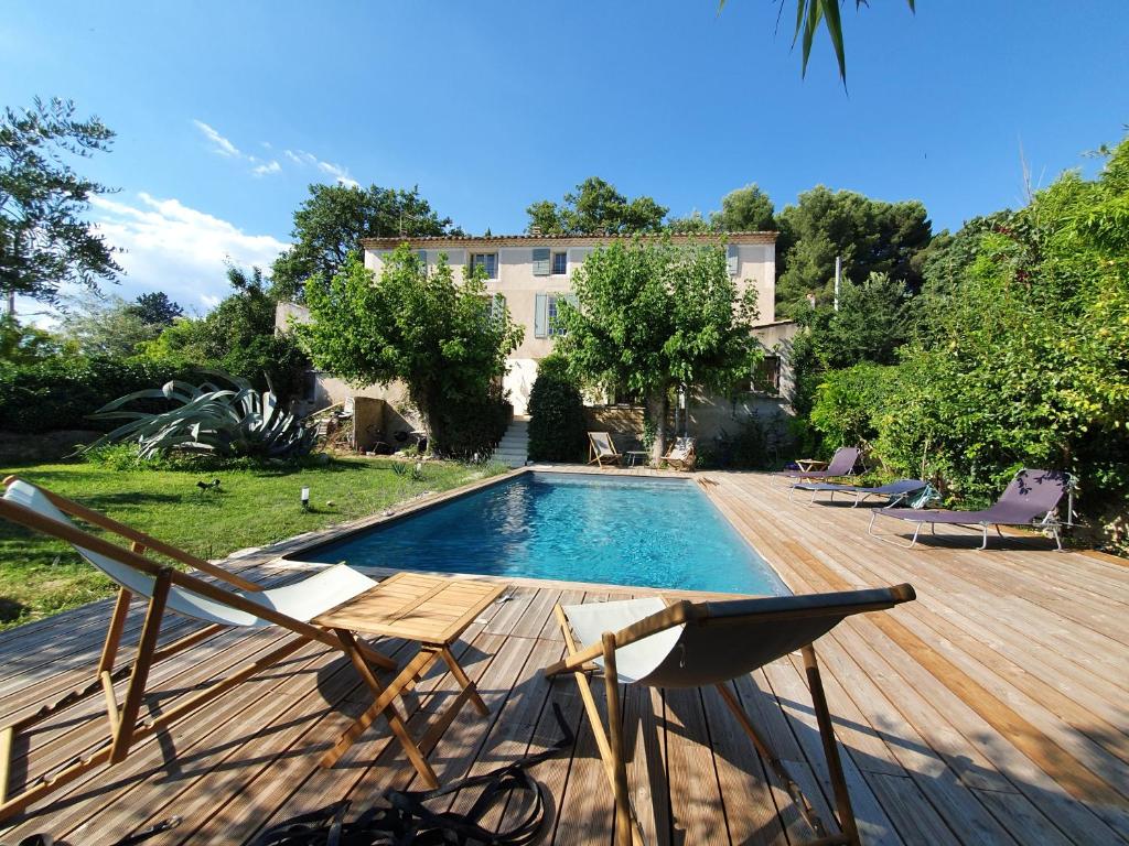 une piscine avec deux chaises et une maison dans l'établissement Mas de Mazan, à Mazan