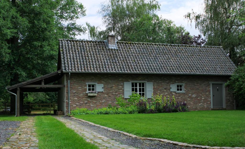 uma casa de tijolos com garagem e relva verde em De Hoog Weyen em Halen