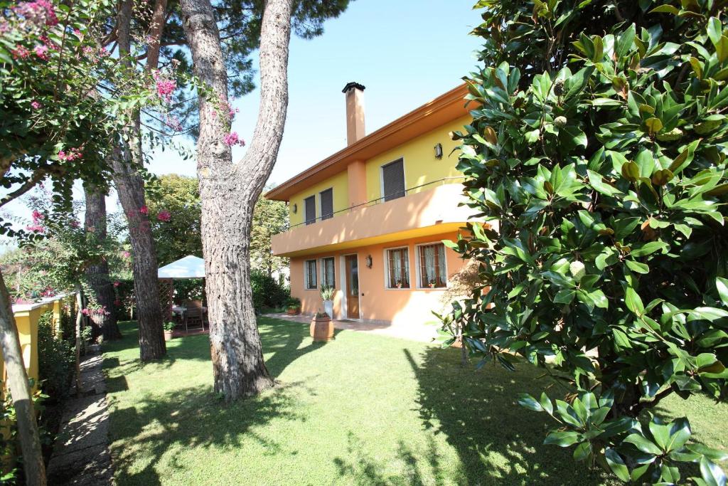 ミラーノにあるB&B Ca' Loiの目の前に木々が生い茂るオレンジの家