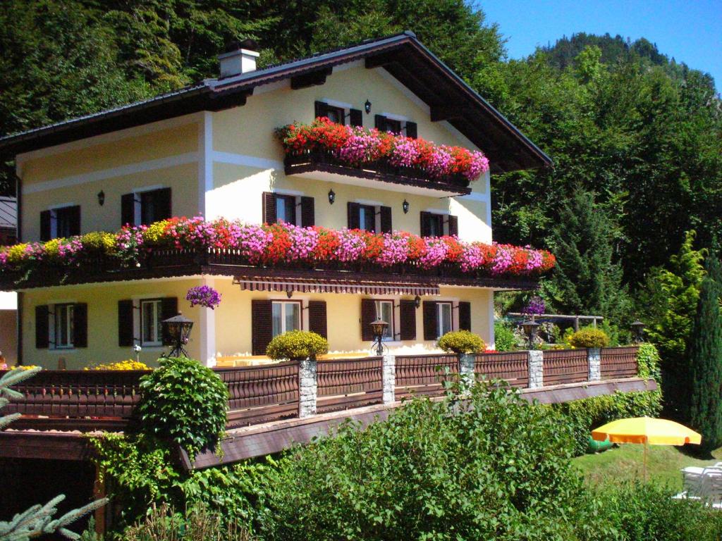 ein Haus mit vielen Blumen auf dem Balkon in der Unterkunft Haus Ebner in Sankt Gilgen