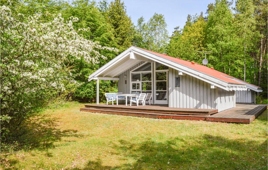 a cottage with a table and chairs on a deck at 2 Bedroom Lovely Home In Sæby in Sæby