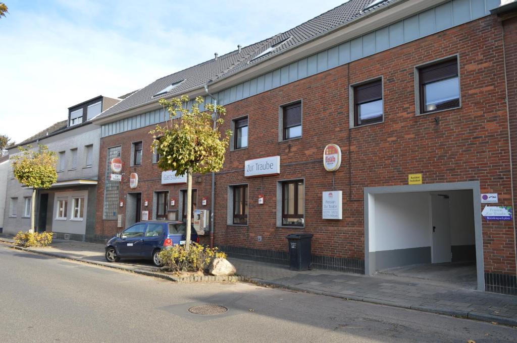 a brick building with a car parked in front of it at Pension Zur Traube in Bergheim