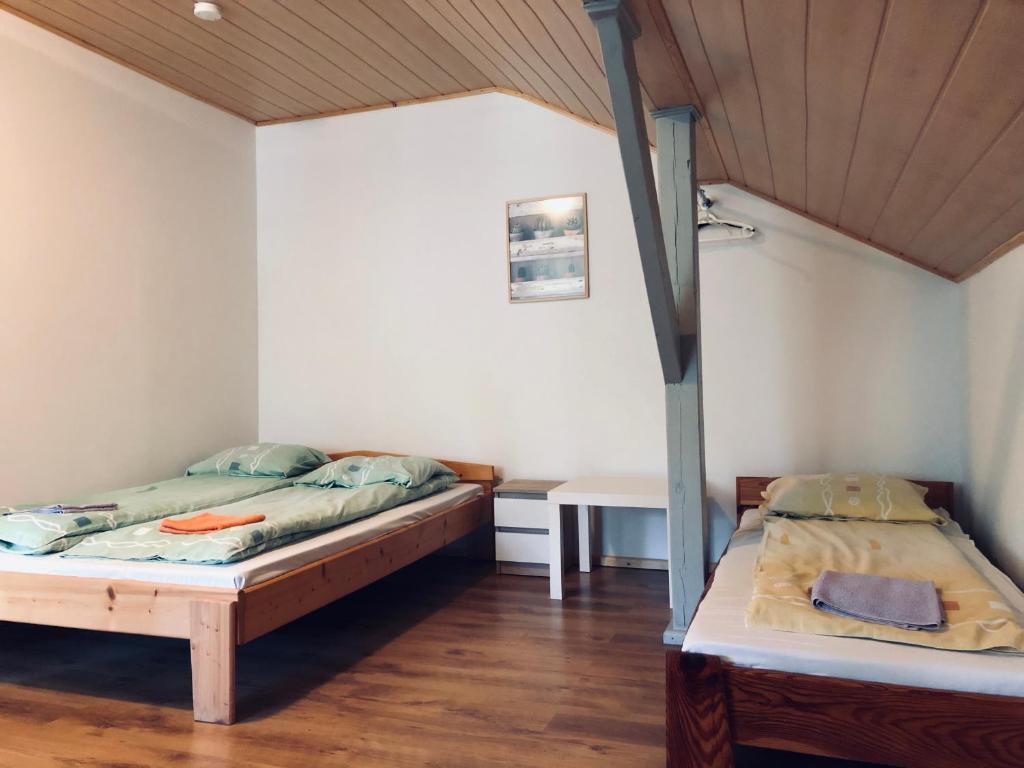 Habitación con 2 camas y mesa. en Rezydencja pod Gwiazdami en Legarda