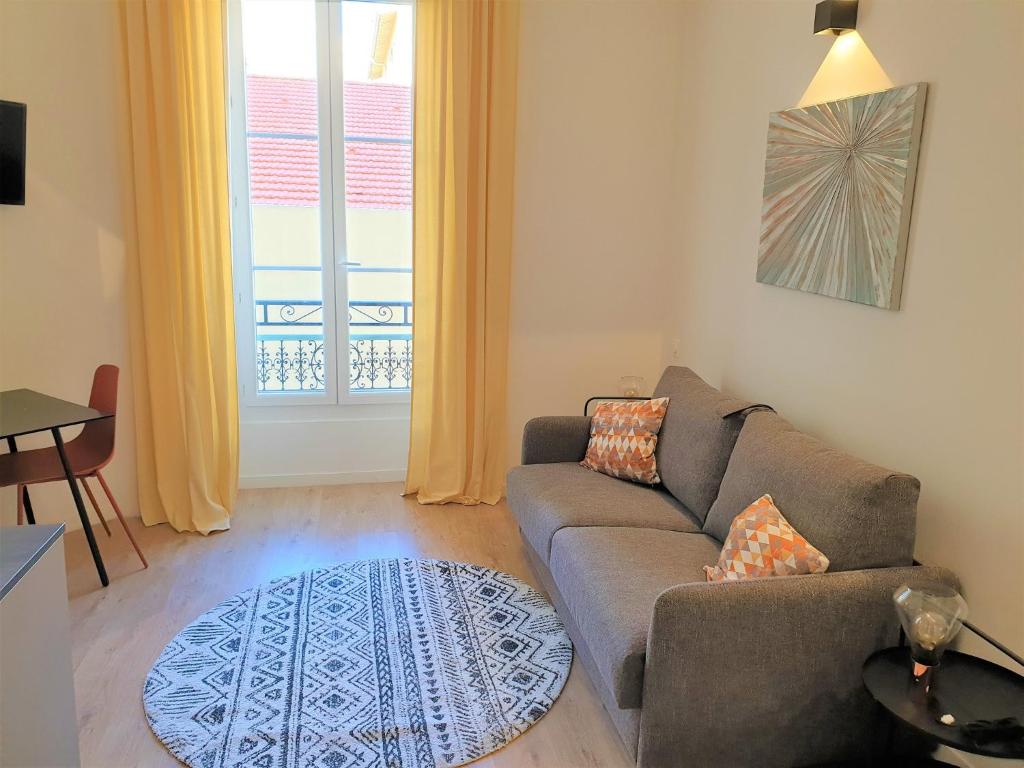 un salon avec un canapé et une fenêtre dans l'établissement STUDIO HYPERCENTRE-201, à Nice