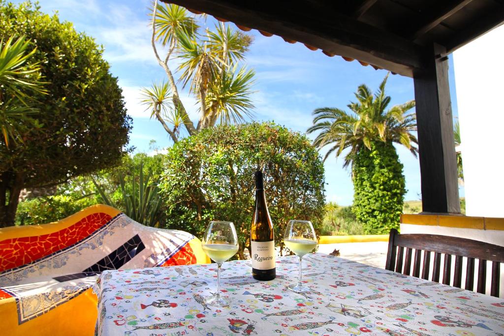 una botella de vino sentada en una mesa con dos copas en Casa Boavista en São Martinho do Porto