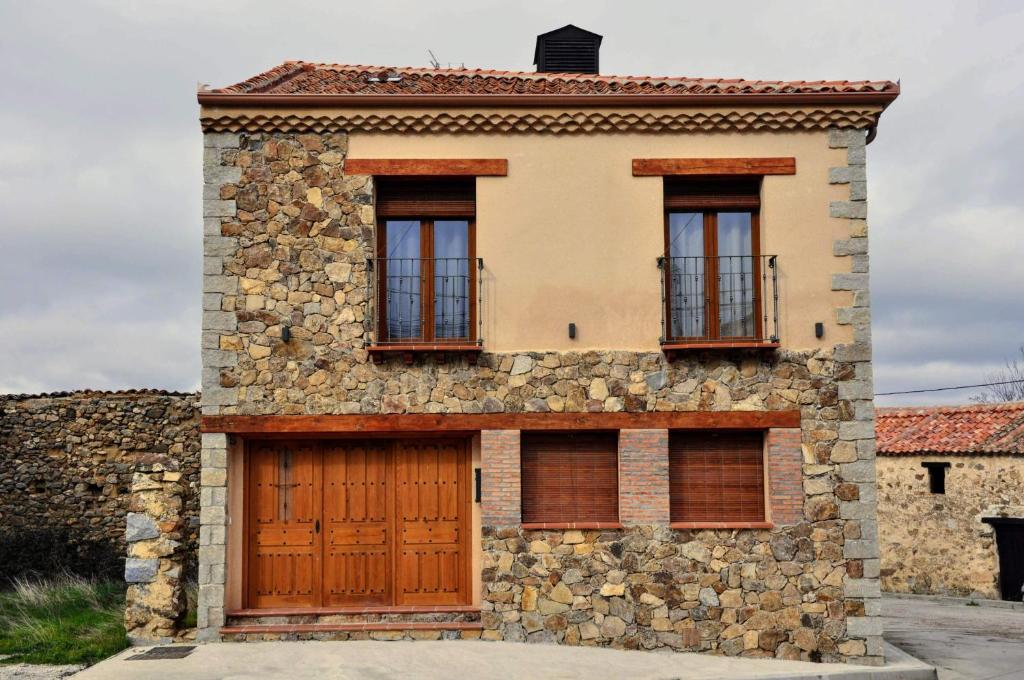 Casa de piedra con puerta de madera y 2 ventanas en LA FUENTE DE CABANILLAS, en Cabanillas del Monte