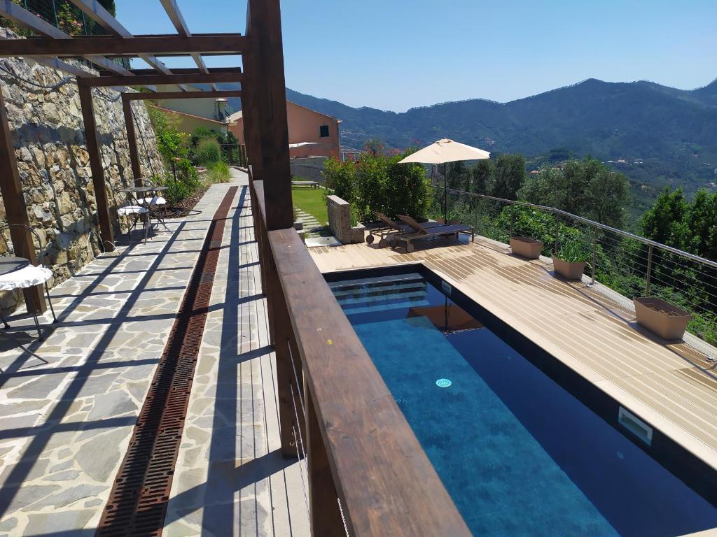 a swimming pool with a wooden deck and a house at L'Antico Borgo B&B in Levanto