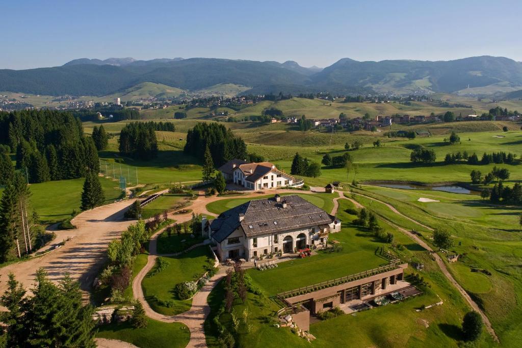 an aerial view of a large house on a green field at Meltar Boutique Hotel Golf & SPA in Asiago
