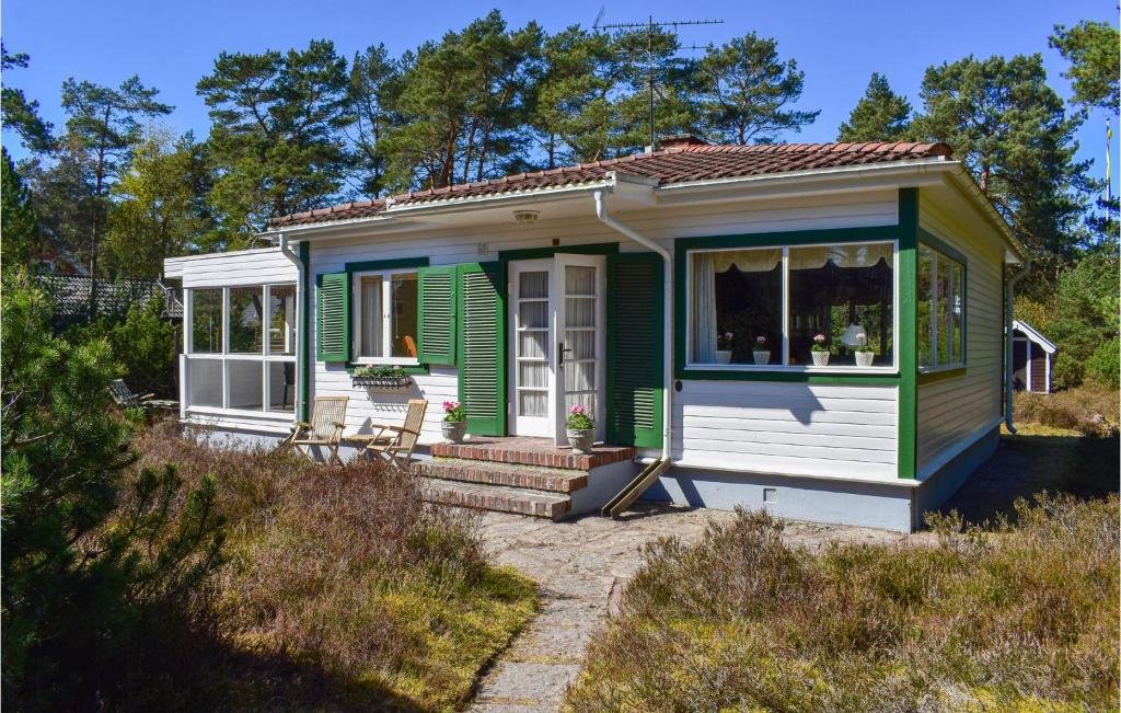 een groen en wit tiny house met een veranda bij Awesome Home In Hllviken With Kitchen in Höllviken