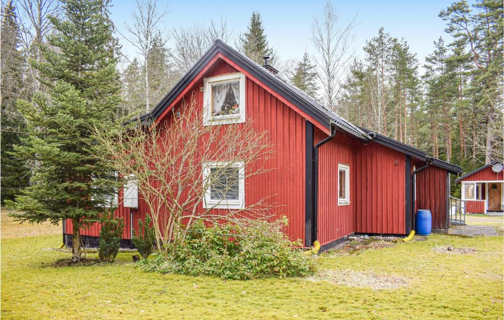 a red house with a tree in front of it at Beautiful Home In Lnneberga With 2 Bedrooms in Lönneberga