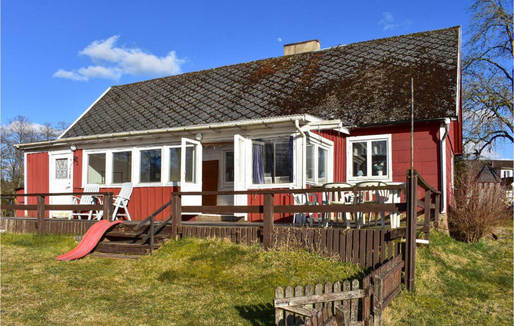 een rood-wit huis met een speeltuin bij Pet Friendly Home In Vittsj With Kitchen in Vittsjö