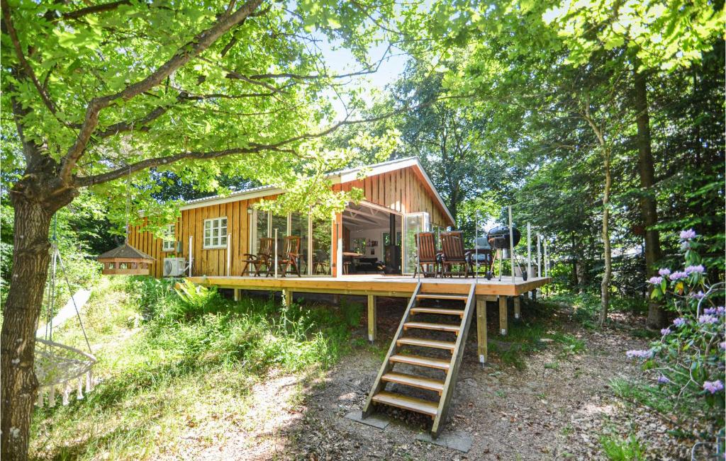 a tiny house in the woods with a ladder at 3 Bedroom Awesome Home In Glesborg in Glesborg